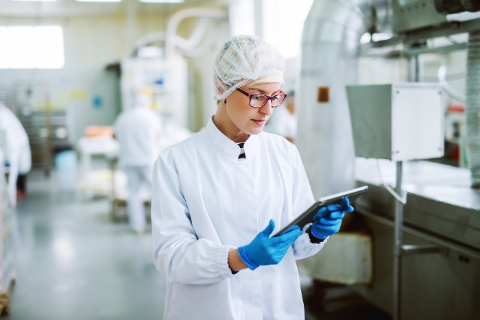 female-worker-using-tablet-controling-products-while-standing-food-factory-1