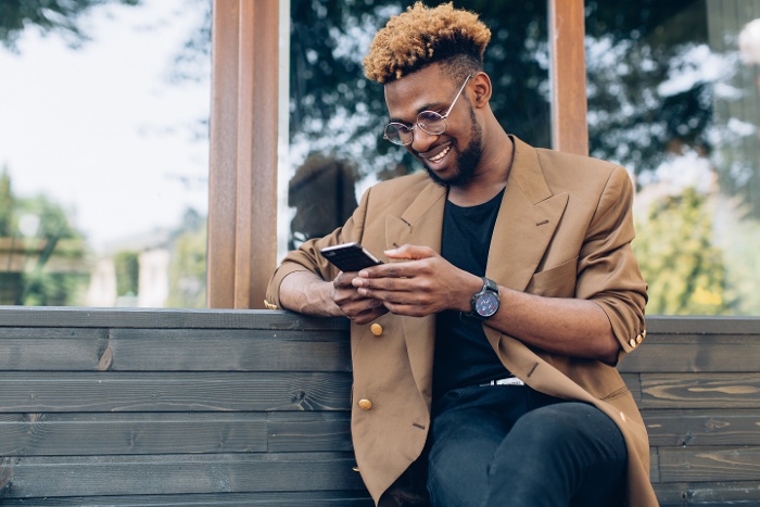 a man sitting on a bench using his phone